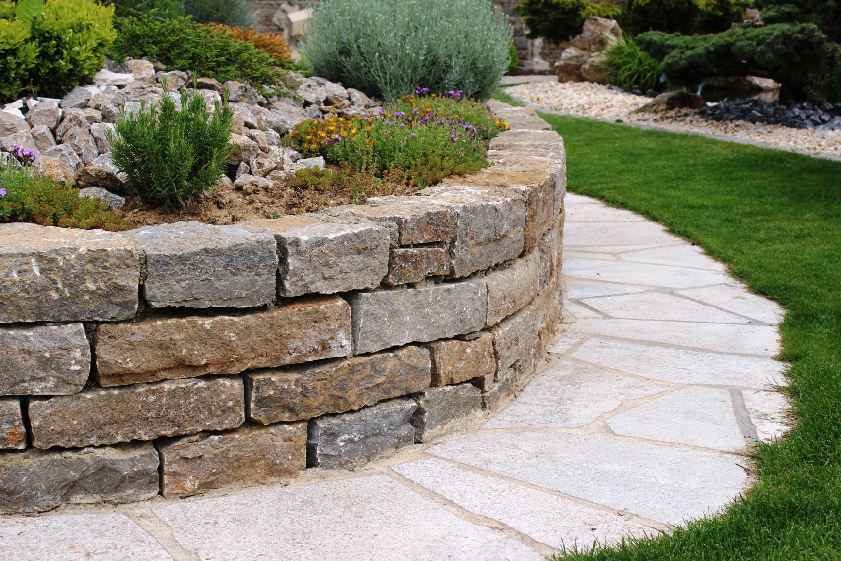 Eine abgerundete Mauer aus Krustenmauersteinen