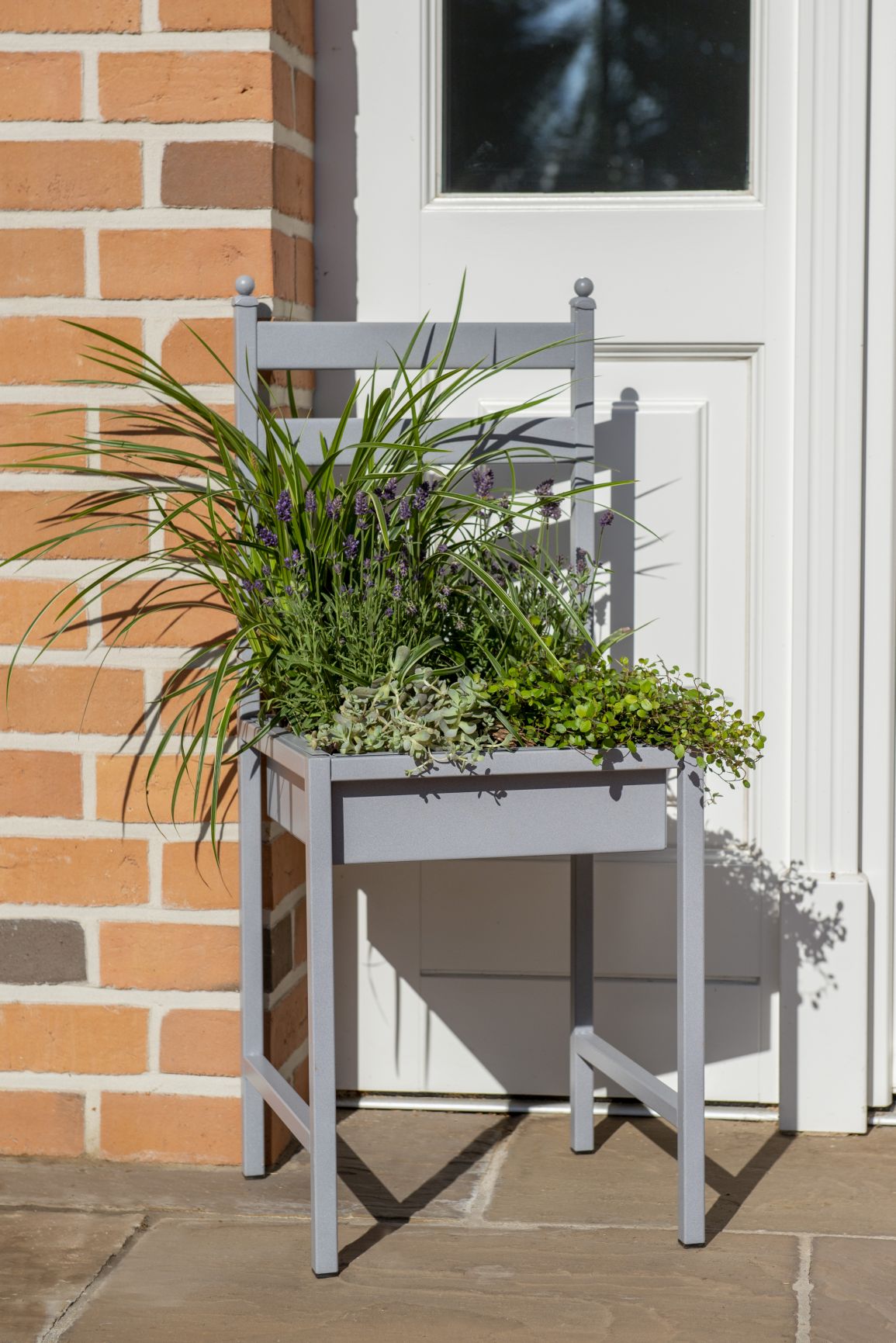 Grauer Metall Stuhl zum Bepflanzen